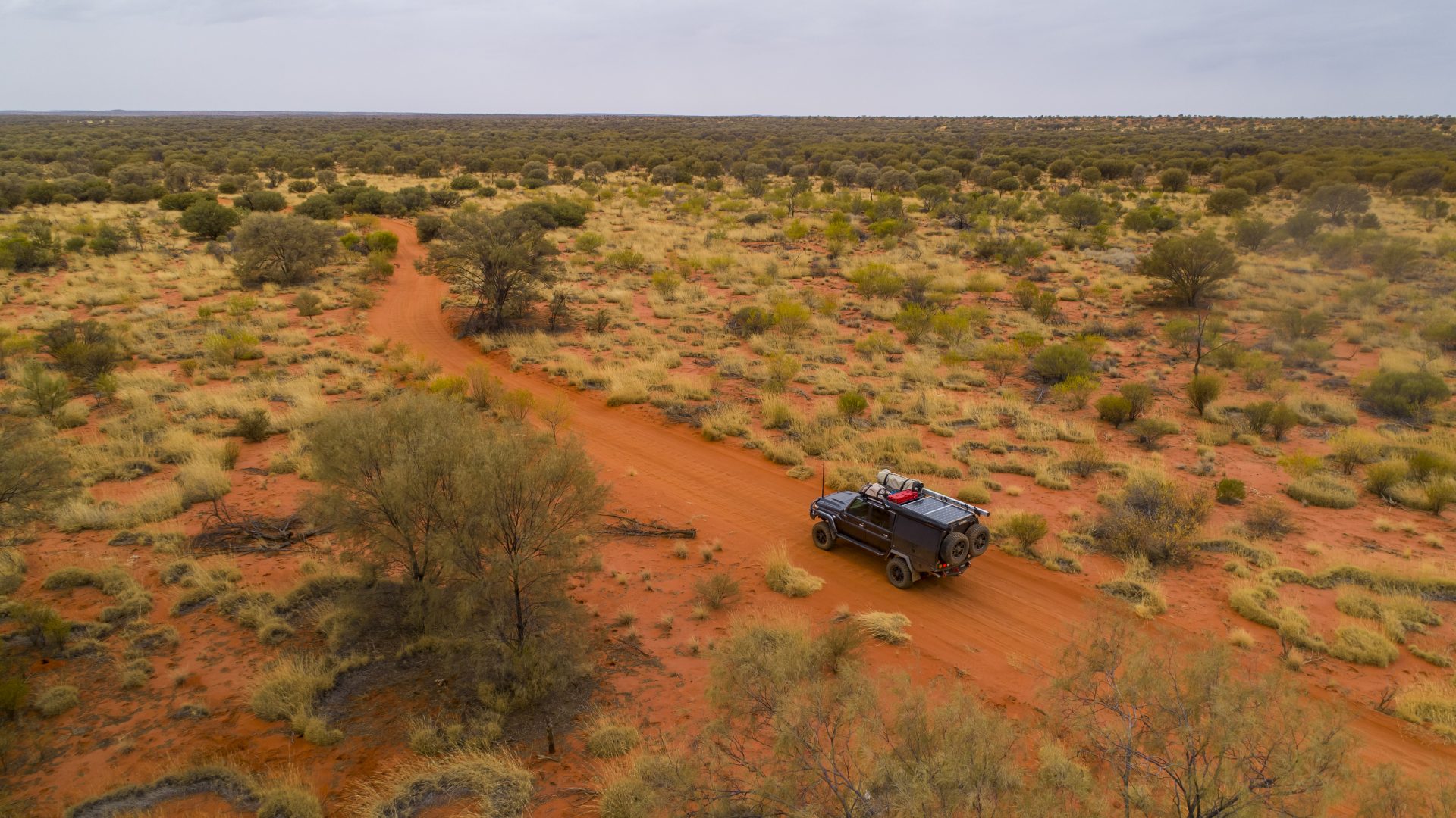 Four-wheel drive exploring a vast Australian outback landscape